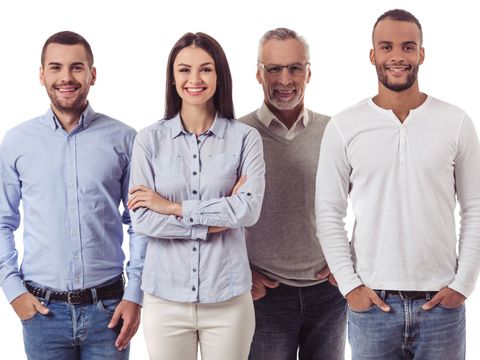 Gruppe aus vier Personen ist der Kamera zugewandt und lächelt