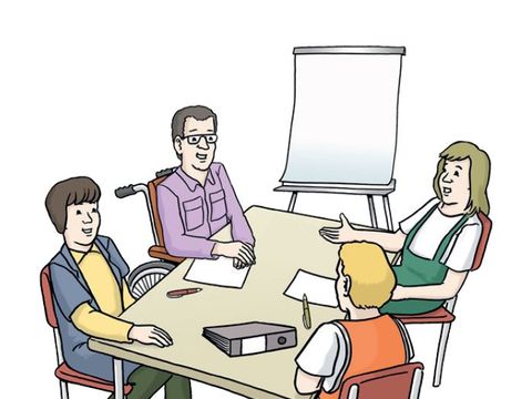 Bild von vier Personen, die um einen Tisch sitzen.
