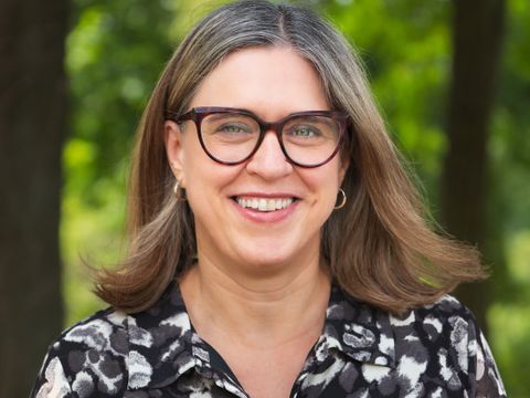 Die Ansprechpartnerin für den Inklusionspreis, Heike Neubrand, lächelt. Das Foto wurde in einem Park aufgenommen.