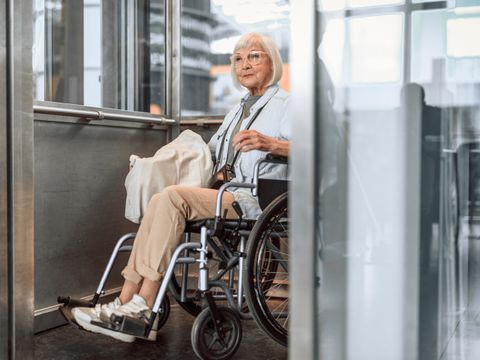 Mature woman in wheelchair using elevator