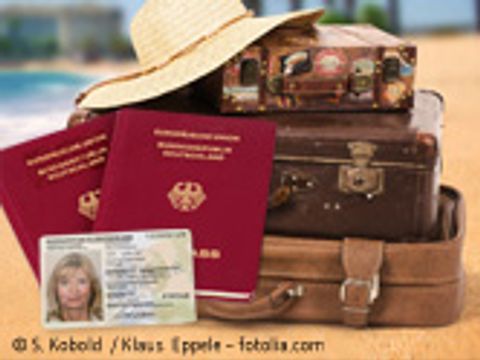 Stapel Koffer, im Vordergrund Reisepass und Personalausweis