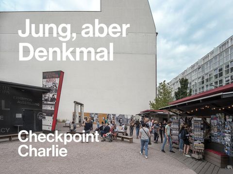 Blick auf eine der Brandwände am Checkpoint Charlie. Die Freiflächen werden heute für Informations- und Verkaufsstände genutzt.