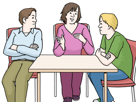 Drei Personen sitzen am Tisch, die Person in der Mitte vermittelt zwischen den beiden anderen Personen