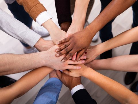 Verschiedene Menschen geben sich einander die Hand