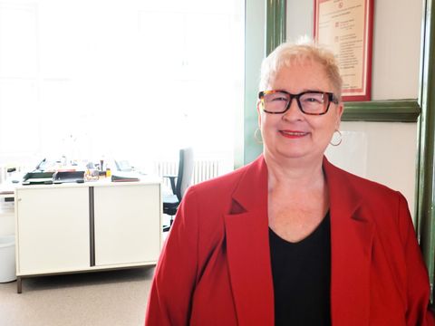 Eine Frau steht an einer offenen Bürotür