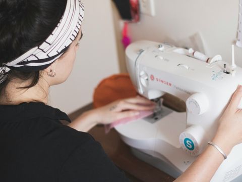 Eine Frau näht etwas an einer Nähmaschine
