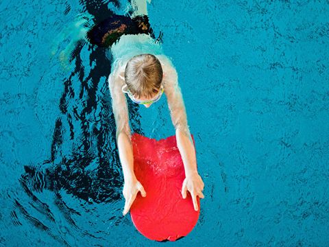 Kind im Schwimm-Becken mit Schwimm-Hilfe.