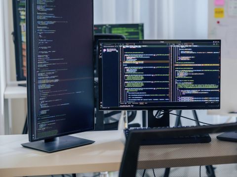 Bildschirme und Laptop auf einem Schreibtisch