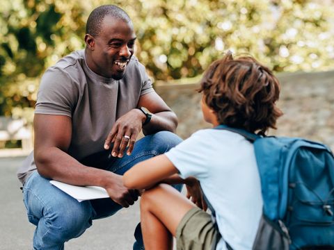 Lehrer unterhält sich mit Schüler auf dem Schulgelände