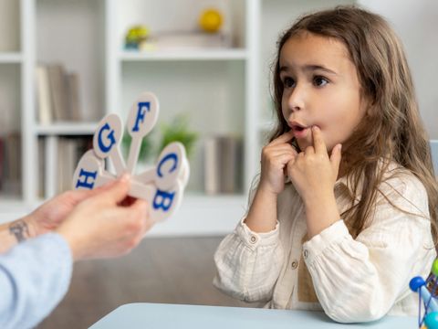Logopädie - Ein Kind macht Sprachübungen nach Vorgabe