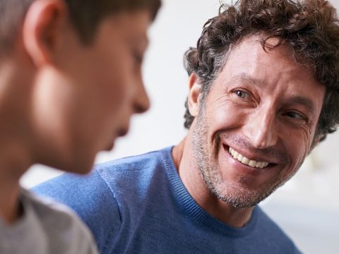 Pädagoge unterhätl sich mit einem Jungen