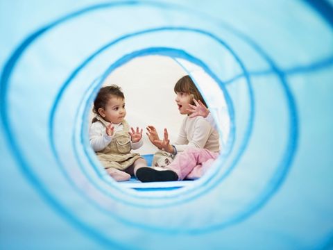 Baby und Kleinkind sitzen sich gegenüber