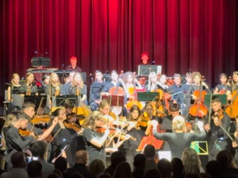 Konzert auf einer Bühne mit rotem Vorhang