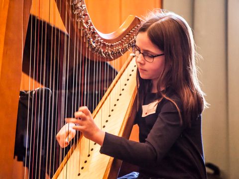 Mädchen spielt Harfe