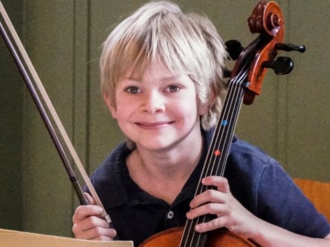 Glücklicher Junge mit Cello.