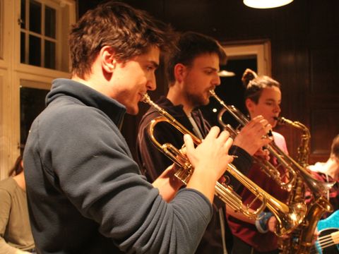 Zwei Trompeter und eine Saxophonistin spielen