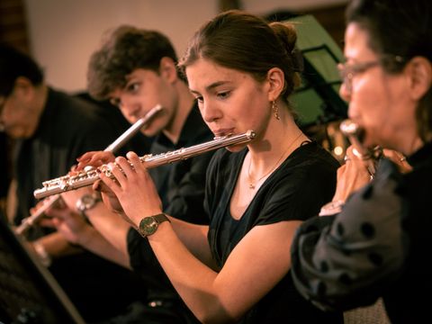 Menschen spielen Querflöte im Orchester