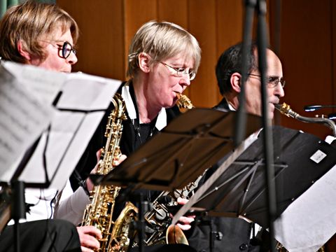 Zwei Frauen und ein Mann spielen Saxophon