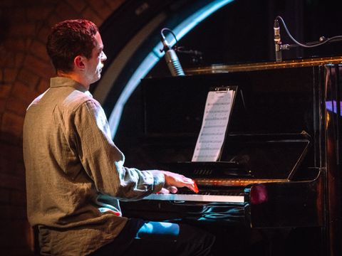 Junger Mann am Klavier in einem Jazzclub