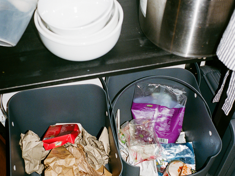 Zwei Müllbehälter für unterschiedliche Abfallarten in einer Küche, gefüllt mit Verpackungen. Das Bild fördert korrekte Mülltrennung und Recycling im Alltag.