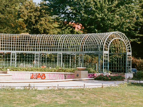 Der Reuterplatz in Berlin mit grünen Lauben und Blumenbeeten. Diese Aufnahme zeigt die Grünflächen in Neukölln, die zur Lebensqualität und Sauberkeit des Bezirks beitragen.