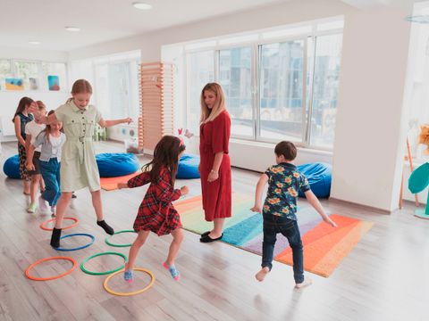Spielende Kinder mit Trainerin