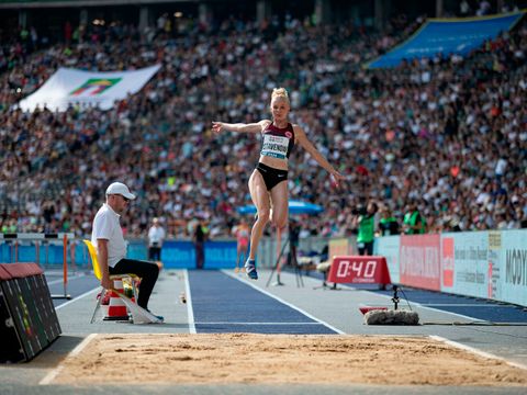 Sportlerin beim Weitsprung im Stadion