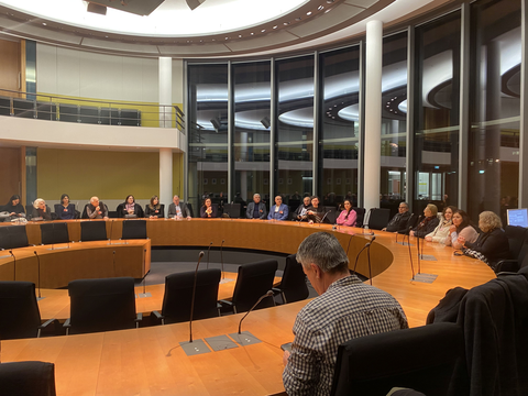 Menschen diskutieren mit MdB Hakan Demir im Ausschusssitzungssaal des Paul-Löbe-Hauses
