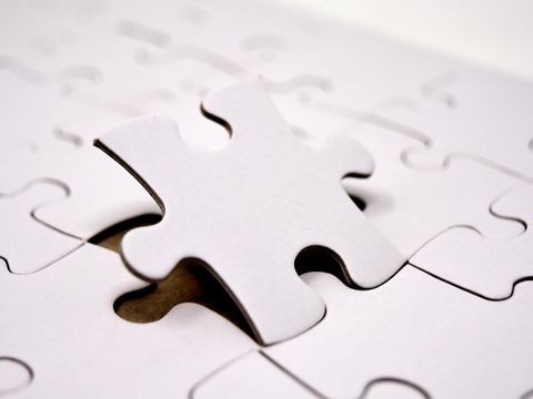Weißes Puzzle, ein Puzzleteil leicht angehoben