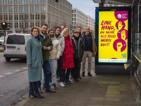 Beteiligte der Kampagne an einer BVG-Haltestelle mit Plakat (Bild: LSVD Verband Queere Vielfalt Berlin-Brandenburg e.V.)