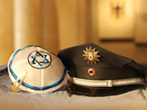 Kippa und grüne Polizeimütze