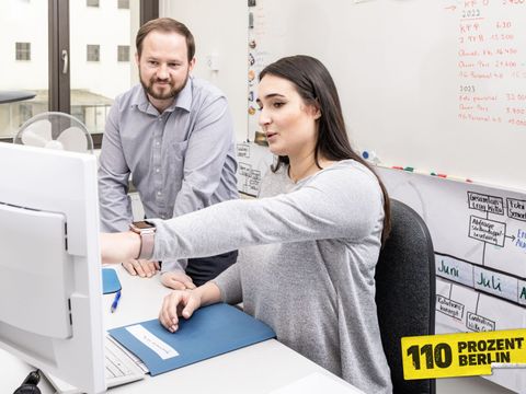Mitarbeitende vor einem PC am diskutieren