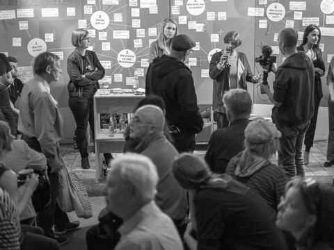 Persone sprechen vor Stellwänden