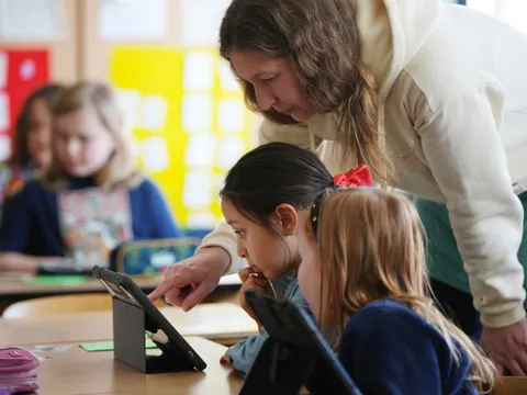 Lehrerin unterrichtet Schulkinder mithilfe eines Tablets