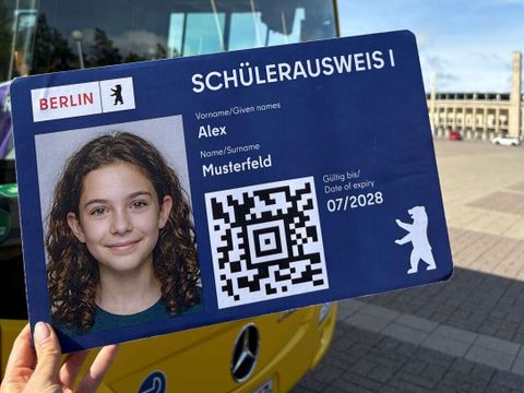 Der neue Schülerausweis mit integrierter Fahrkarte. Im Hintergrund ist ein BVG-Bus zu sehen. Das Foto auf der Fahrkarte wurde durch KI erstellt.