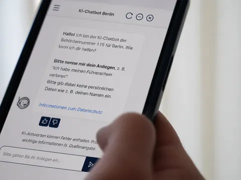 Eine Hand hält ein Smartphone. Auf dem Bildschirm ist der Chatbot zu sehen.