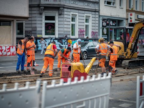 Beschäftigte im Straßenbau bei Arbeiten an einem Straßenbahngleis