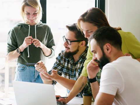 Gruppe von Erwachsenen bespricht sich im Meetingraum