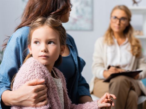 Mutter sitzt mit Kind bei einem Beratungsgespräch