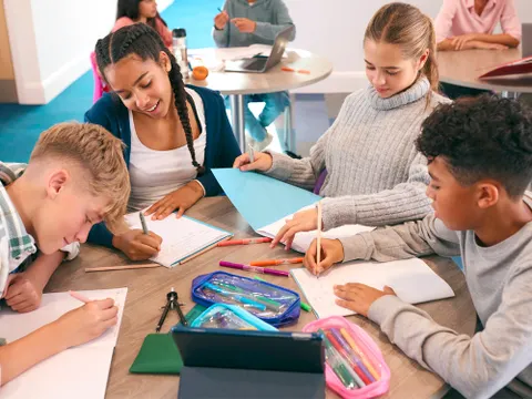 Grundschülerinnen und Grundschüler befassen sich in Gruppenarbeit mit Aufgaben