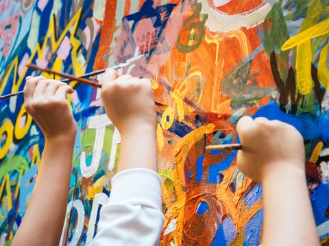 Mehrere bemalen eine Wand mit Pinseln - Nahaufnahme