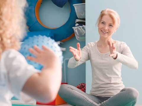 Eine Therapeutin macht Übungen mit einem Kind