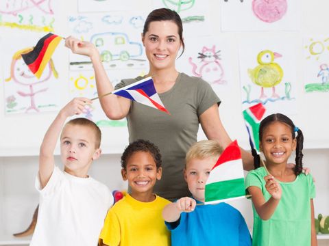 Schulkinder winken mit Fähnchen