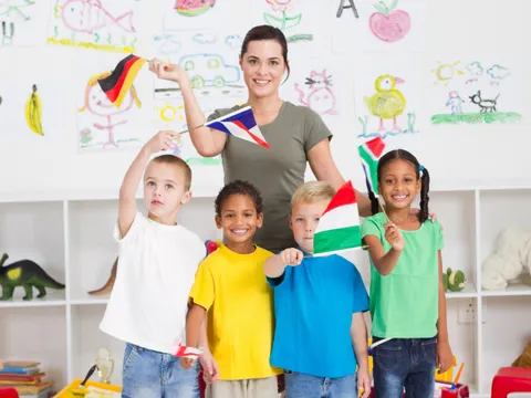 Schulkinder winken mit Fähnchen