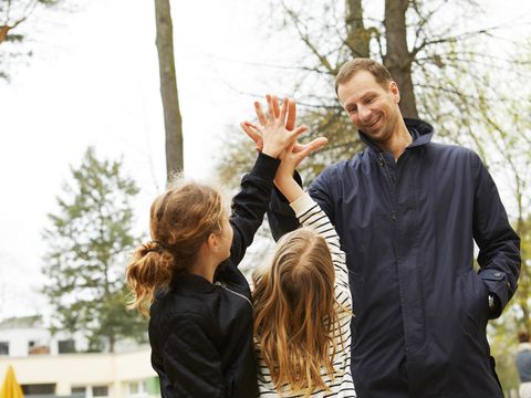 Schüler/-innen klatschen mit Lehrer ab