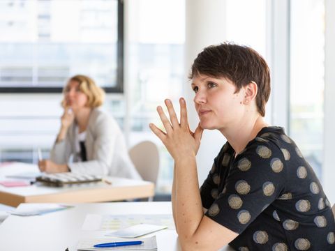 Lehrkraft hört in Seminar zu
