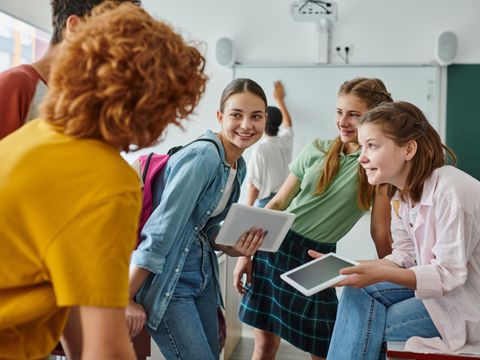 Teenage students engaging and laughing in a vibrant classroom during back-to-school season