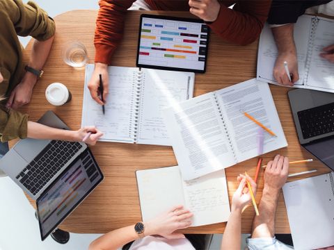 Vogelperspektive von Gruppenarbeit verschiedenen Arbeitsutensilien