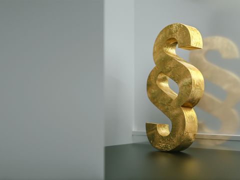 goldener Paragraph lehnt an Wand