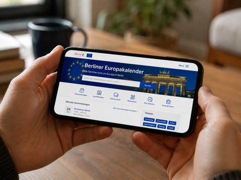 Person hält Handy und schaut in den digitalen Europakalender